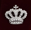 Macro shot of silver alloy crown brooch with sparkling crystals on red velvet - Silver Crown