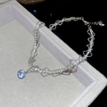 Gros plan d'un pendentif en zircon brillant sur une chaîne argentée multicouche - Argenté