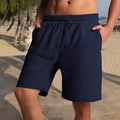 Men's navy blue textured drawstring casual shorts shown on a beach by a male model - S / Navy Blue