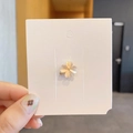 Elegant gold four-leaf clover brooch with beige opal petals on a white card display - Clover Style
