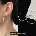 Detail shot of 4cm silver twist C-shaped hoop earrings on model and black background - Medium Silver Hoop (35#)