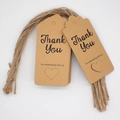 Close-up of brown kraft paper thank you tags with heart cutout and twine strings - 11-Kraft Heart Cut-out
