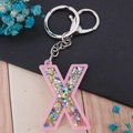 Pink acrylic letter X keychain with colorful star sequins and durable metal lobster clasp - Letter X