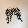 Detail von langen goldenen Quastenohrringen mit facettierten schwarzen Perlen und Herzclips - Schwarze Kristall-Quasten-Ohrringe