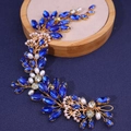 Diadema de novia dorada con cristales azul marino y perlas sobre bandeja de madera - Azul Real