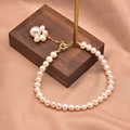 Elegant natural pearl bracelet featuring a golden cat paw charm on champagne silk background - Cat Paw Pendant Bracelet