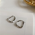 Macro detail of silver geometric twisted triangle earrings with mirror polished finish - Silver Twisted Geometric Hoop (E051)