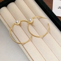 Orecchini a cerchio dorati a forma di C con perla bianca su una scatola per gioielli - Cerchio Grande Forma C con Perla / Oro