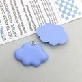 Detalle de dos colgantes de nube azul en resina con anillos de metal para joyería DIY - Nube de Resina Azul