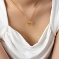 Collana in acciaio al titanio dorato con ciondolo a cuore floreale e lettera su modella - Collana Oro