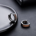 Vue détaillée de créoles en métal noir serties de zircons cubiques orange vif - Noir Zircone Orange