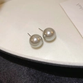 Macro shot of gray pearl stud earrings with metallic luster on white background - 12mm