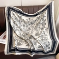 Detail of a large silk scarf with black and white floral prints on a leather sofa - Thistle Floral Print White (XW-195)