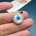 Close-up of golden evil eye shell pendant with sparkling zircons held in hand - Style E