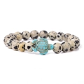 Beaded Dalmatian Jasper bracelet featuring a turquoise turtle charm on white background - Dalmatian Jasper