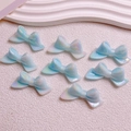 Macro shot of iridescent blue bow-shaped resin beads for DIY jewelry and phone charms - 20x46mm/Aperture Approx 2.5mm / Luminous Iridescent Blue