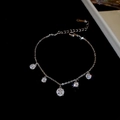 Detail van verstelbare zilveren armband met vijf sprankelende zirkonia hangers - Zilveren vijf ronde zirkonen stijl