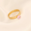 Detail eines rosa Zirkonia-Rings mit Vier-Krallen-Fassung und goldenem Ringband - US 8 / Rosa