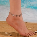Tobillera de plata con colgantes de nácar blanco en modelo con fondo de mar y playa - Tobillera de Concha Blanca Redonda Color Acero