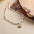 Detailed close-up of a pearl jewelry set with necklace and earrings on a wooden stand - Gold Pearl Four-Leaf Clover Set
