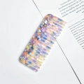 Detailed close-up of a wide-tooth acetate comb with a purple marbled pattern on a white base - Purple Blue Mottled