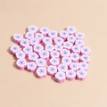 Détail macro de perles fleurs en argile polymère de 10mm rose et bleu pour bijoux DIY - Rose