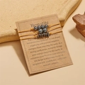Dreiteiliges Hämatit-Stein-Armband-Set mit gelben geflochtenen Kordeln auf Displaykarte - Hämatit