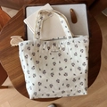 Dettaglio borsa tote in cotone floreale con etichetta su scrivania in legno decorata - Base Beige Piccoli Fiori Marroni