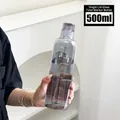Γκρι γυάλινο μπουκάλι νερού 500ml με χρονική κλίμακα που κρατιέται από μοντέλο - Μικρό Γκρι Καπνού