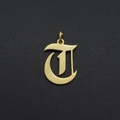 Macro shot of a gold gothic letter T pendant with a polished mirror finish on black - Letter T