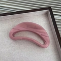 Dettaglio di una grande molletta per capelli rosa malva ad arco su un vassoio in lino grigio - Rosa