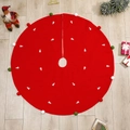 Red Christmas tree skirt with white tree patterns and colorful pom-pom edge on wooden floor - Red Embroidery Style