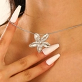 Detailed view of a silver floral pendant necklace with a delicate snake chain on a model - Steel Color Cherry Blossom (0606)
