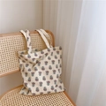 Borsa tote in tela con stampa floreale vintage appoggiata su sedia in rattan - Beige Con Fiori Viola