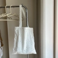 Close-up of white cotton tote bag featuring intricate floral embroidery and cut-out lace - Double Strap Shoulder Bag