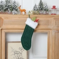 Calza di Natale in maglia verde con bordo in finta pelliccia bianca sul camino - Verde