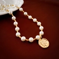 Vue macro du pendentif pièce de monnaie dorée et collier de perles au style vintage - Or (Plaqué Or Véritable)