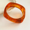 Detailed view of amber resin square bangle with elegant marble texture on white surface - Bangle-Coffee