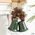 Dark green metal bells with plaid bow and pine cone hanging on a vintage fireplace - Painted Green Open Double Bells