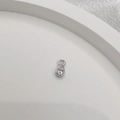 Macro shot of silver teardrop charm with clear zircon bezel setting on white tray - 925 Sterling Silver/Zirconia / Silver Waterdrop Style
