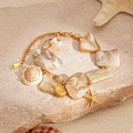 Detalle del collar playero con conchas naturales, estrellas de mar doradas y perlas - Estilo de Pulsera Blanca
