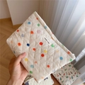 Detailaufnahme der gesteppten cremefarbenen Kosmetiktasche mit bunten Punkten - Bunte Punkte