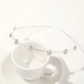 Detail shot of silver leaf headband with seven sparkling rhinestone flowers on a cup - Metal Headband-Plum Silver White Zirconia