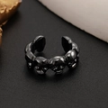 Nahaufnahme des gotischen schwarzen Totenkopfrings mit Schnitzerei und offenem Ringband - Totenkopfstil / Gunmetal