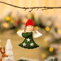 Detail of Christmas angel doll ornament hanging on tree branch with festive warm lighting - Green