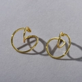 Detail of twisted gold metal hoop earrings with a fluid minimalist spiral design - Gold Ear Clips (Pair)