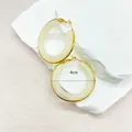 Detail view of 4cm gold stainless steel hoop earrings with white resin inlay - Beige