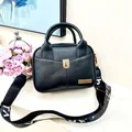 Close-up of black lychee grain texture and gold shield logo on daily crossbody bag - All Black