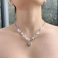 Detalle de collar de cuentas con flores coloridas, perlas blancas y colgante de concha plateada - Caracola Blanco y Rosa