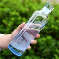 Transparent borosilicate glass water bottle with time markings held against greenery - 500ml / Gradient Blue